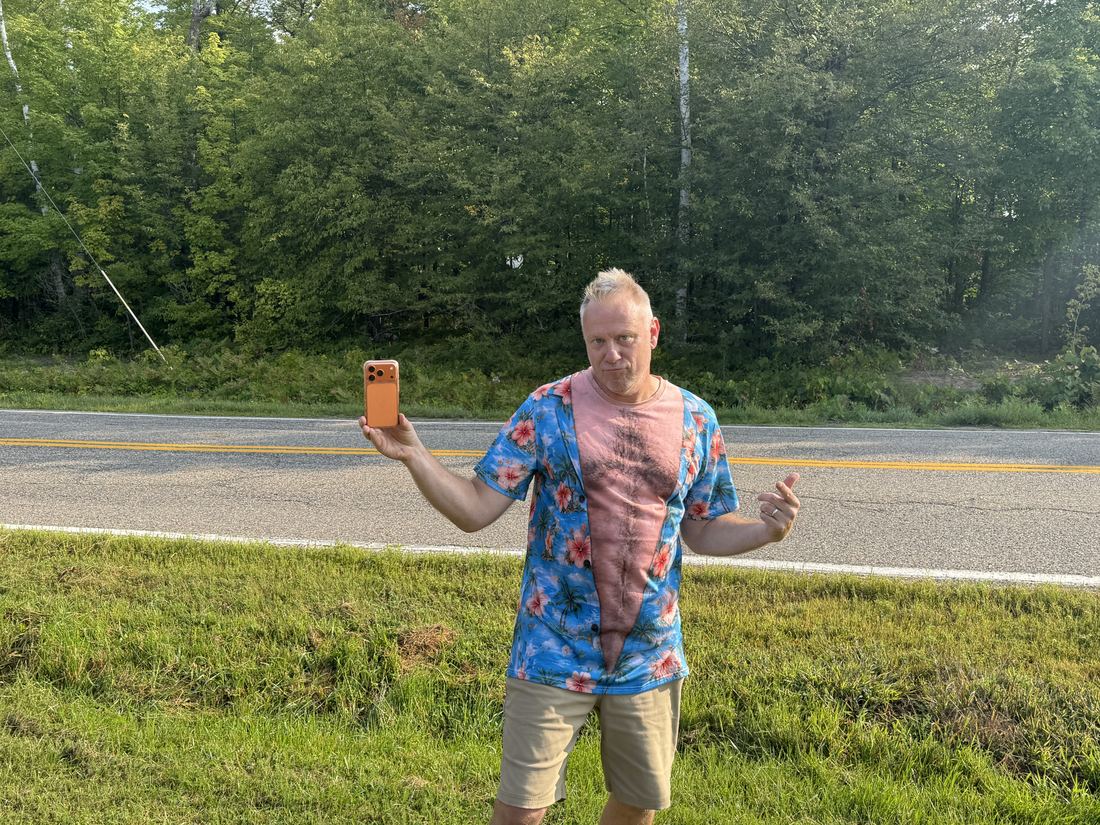 The Race Director on the course road in a tie-dye shirt, holding a phone